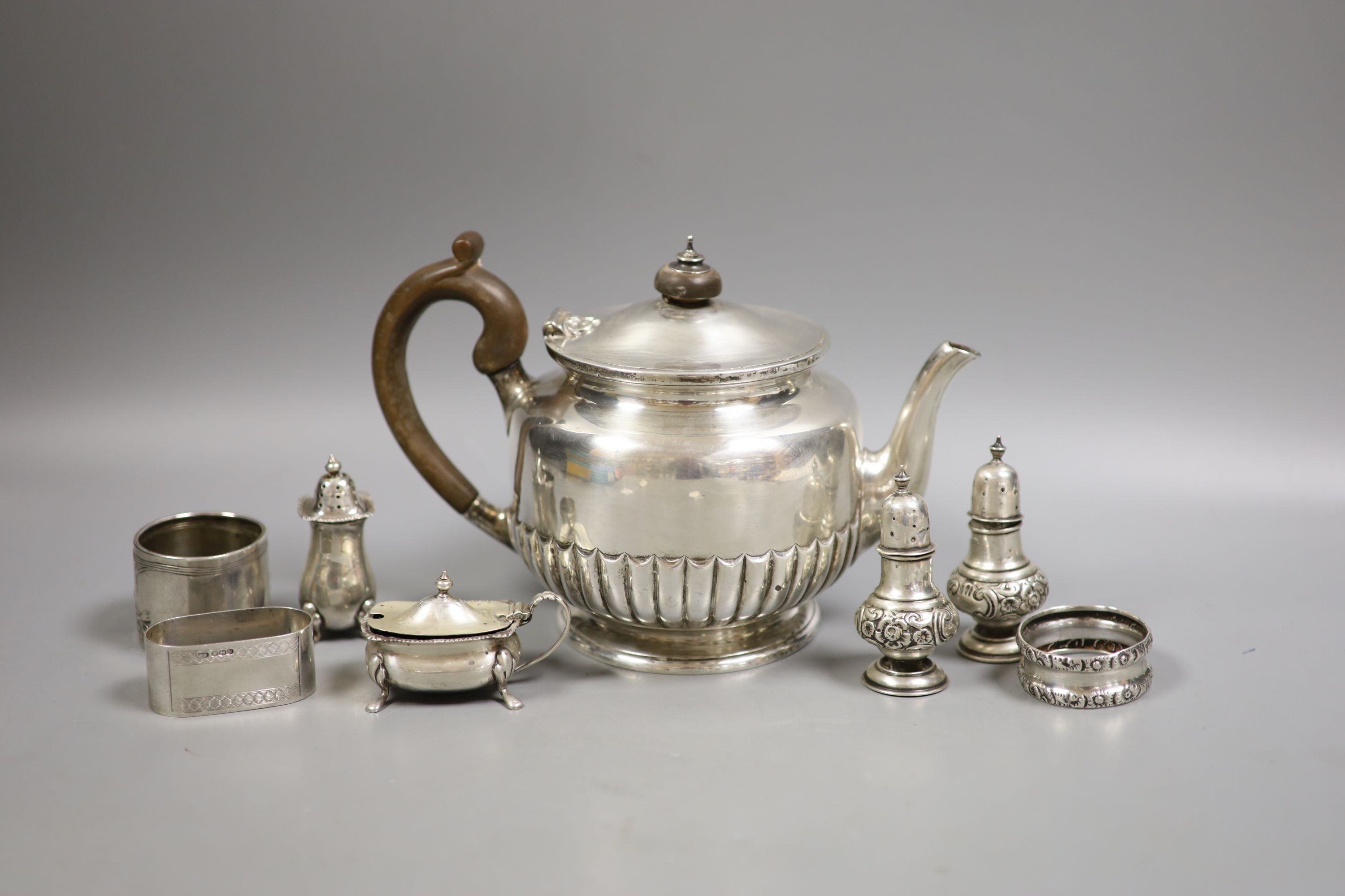 A late Victorian silver teapot, of circular half-fluted pedestal form, London 1899, Edward Barnard & Sons Ltd and a small collection of condiments